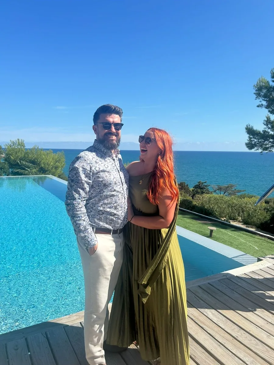 Michelle and Pa by a pool overlooking the sea